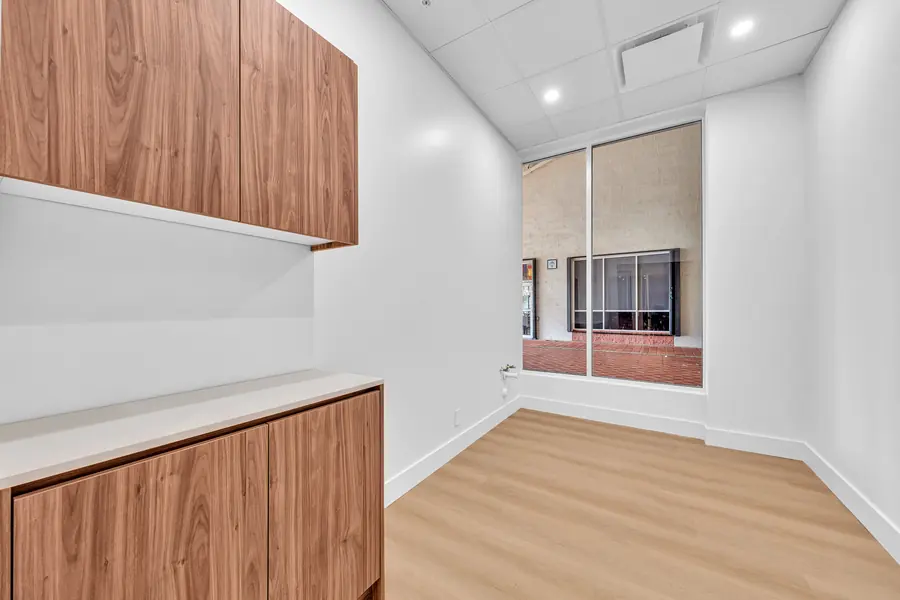 Suite with a large window, walnut upper cabinets and a white counter